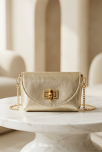Cargar imagen en el visor de la galería, Bolso metalizado sobre una mesa moderna de mármol, con fondo elegante y minimalista
