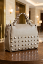 Cargar imagen en el visor de la galería, Bolso sobre una mesa de nogal con un elegante fondo de hotel
