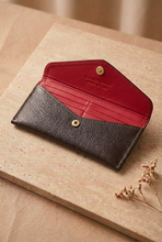 Cargar imagen en el visor de la galería, Interior rojo de la cartera abierta sobre mesa de mármol beige

