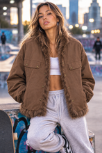 Cargar imagen en el visor de la galería, Modelo con pantalón de chándal gris llevando la chaqueta reversible de pelo marrón
