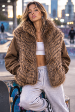 Cargar imagen en el visor de la galería, Modelo joven con chaqueta de pelo en estilo sport-chic, fondo urbano juvenil
